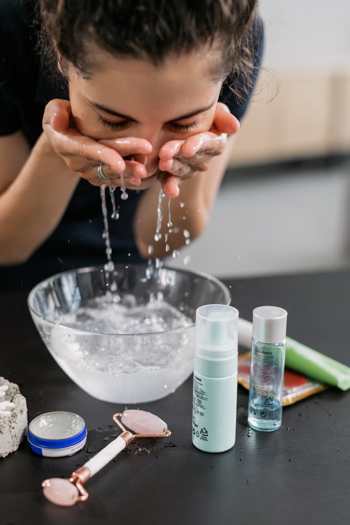 A woman practicing her skincare routine with a face wash and products on a counter.